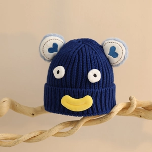Détails de la texture côtelée du bonnet en tricot bleu marine avec yeux de cartoon