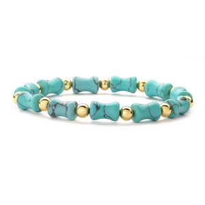 Detail of beaded bamboo bracelet featuring turquoise style stones and golden metal beads