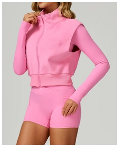 Détail de la fermeture éclair et de l'ourlet côtelé du gilet de sport en polaire rose
