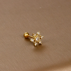 Macro shot of gold snowflake stud earring with clear zircon and screw back closure