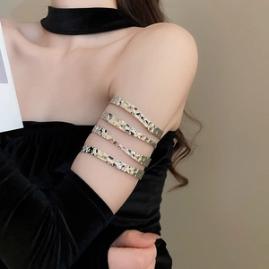 Macro detail of silver layered spiral metal arm cuff bracelet on upper arm