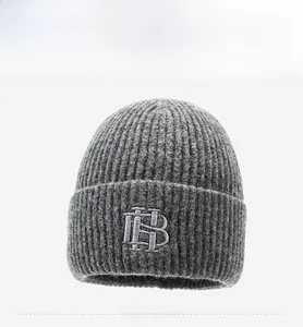 Vue détaillée du bonnet en maille gris foncé avec broderie HB et texture côtelée