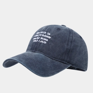 Close-up of vintage washed cotton baseball cap featuring white embroidered slogan text