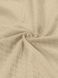 Vista macro che mostra la trama dettagliata a rombi del tessuto beige della felpa