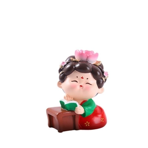 Miniature Tang-style girl figurine reading on desk, traditional Chinese decor