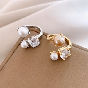 Macro detail of adjustable rings with irregular pearls and zircon on textured silk