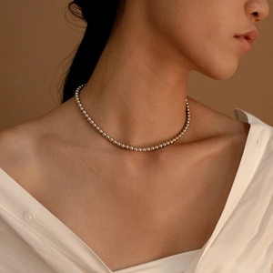 Elegante hochglanzpolierte Silberperlenkette minimalistischer Choker am Modell mit weißem Hemd