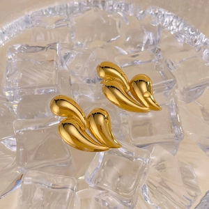 Macro shot of triple teardrop earrings with elegant golden metallic finish and smooth curves