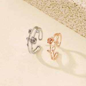 Macro detail of rose flower open rings in silver and rose gold finishes with floral design