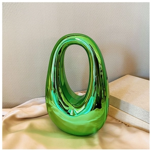 Detailed view of glossy green oval acrylic bag with mirror finish and cutout handle