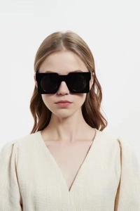 Close-up of oversized black square frame sunglasses with unique geometric round lenses