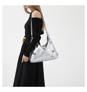 Detailed side view of a silver shoulder bag featuring decorative metal butterfly accents