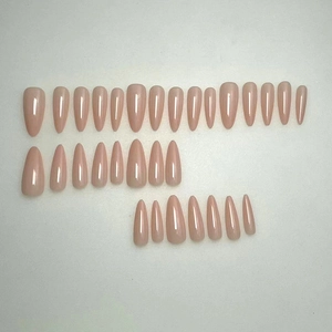 28pcs glossy nude pink press-on nails in long stiletto shape on a white background