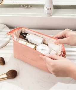 Dettaglio trousse in pelle PU rosa con grande capacità e scritta dorata per viaggio