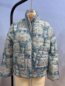Detailed view of floral quilted jacket featuring stand collar and large front pockets