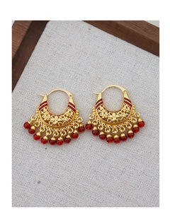Detailed view of vintage gold hollow flower earrings with elegant red bead tassels