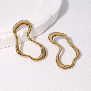 Minimalist 18k gold plated titanium steel wavy hoop earrings on a ceramic tray