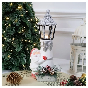 Close-up of Santa Claus lighthouse lantern with warm glowing lights and pine cone decor