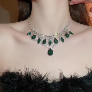 Luxury silver necklace featuring emerald green teardrop pendants and sparkling rhinestones