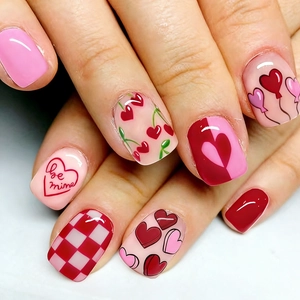 Short press-on nails with red heart patterns and be mine text for Valentine's Day