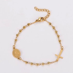 Detailed close-up of gold stainless steel beaded bracelet with cross and Virgin Mary medal