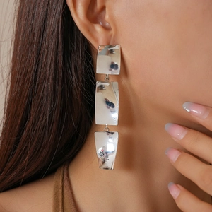 Detail view of 18k gold plated geometric earrings with polished silver square link drops