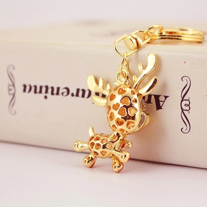 Golden reindeer keychain with hollow heart pattern on vintage book background