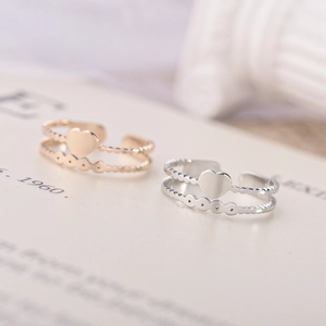 Macro shot of rose gold and silver double-layered adjustable open heart rings