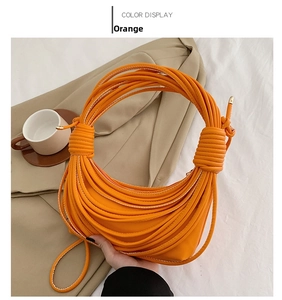 Detailed view of the vibrant orange crescent bag featuring unique layered knotted rope texture