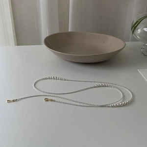 Detail of elegant pearl necklace featuring polished white pearls and gold metal clasps