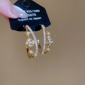 Détail de boucles d'oreilles S925 plaquées or 18k avec fleurs en zircon et couches en forme de C