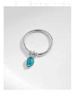 Macro detail of S925 silver ring featuring a blue marquise gemstone pendant and Good Luck text