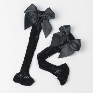 Detail of black fishnet socks featuring large satin bows on the cuffs over white background