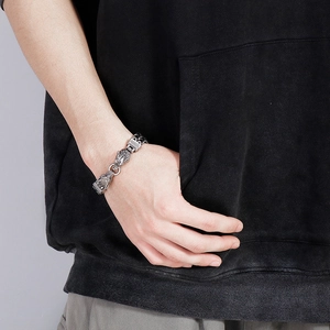 Vue détaillée du bracelet punk en acier à double tête de loup sur un poignet