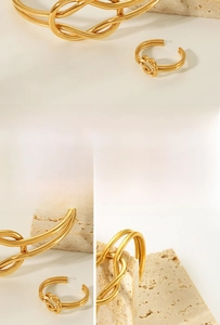 Makroaufnahme von 18K vergoldetem Knotenknoten-Ring und Armreif mit polierter Textur