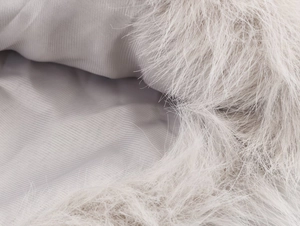 Detail van lichtgrijs imitatiebont met gladde twill voering op een stijlvolle winterjas