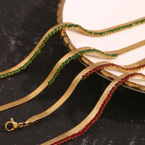 Close-up of gold plated snake chains and colorful zircon tennis bracelets on a plate