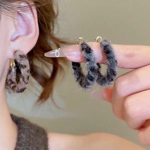 Detail of leopard print faux fur round hoop earrings worn to show texture and size
