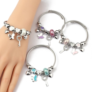 Detail of beaded wire cuff bracelets with heart charms and crystal key pendants