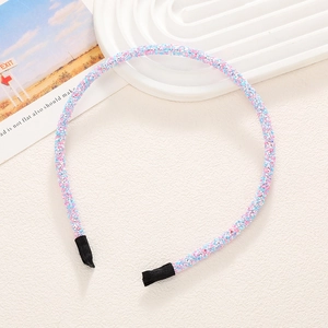 Gros plan d'un serre-tête fin pailleté avec sequins multicolores et embouts en tissu noir