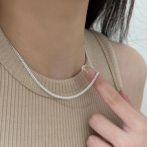 Detail of minimalist 925 sterling silver curb chain necklace shown on a model neck