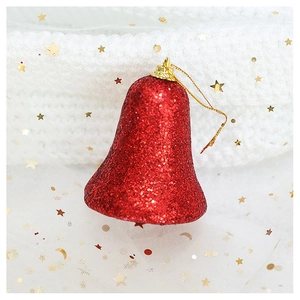 Detail of red glitter Christmas bell ornament with gold string on cozy white knit