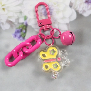 Pink keychain detail featuring transparent butterfly charm, bell and color chain