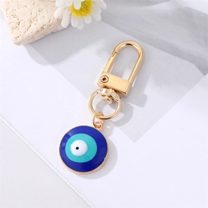 Detailed shot of evil eye keychain with blue enamel inlay and gold-tone lobster clasp