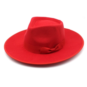 Detailed view of wide-brimmed red wool fedora hat featuring a matching ribbon bow