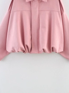 Detailed view of pink suede bomber jacket featuring a smooth hem and fine stitching