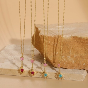 Close-up of golden necklaces with pink zircon hearts and cute bear animal pendants