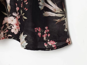 Close-up of floral print on black woven fabric with pink and cream vintage flowers