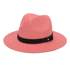 Close-up of pink paper straw Panama hat with black decorative band and gold rivets