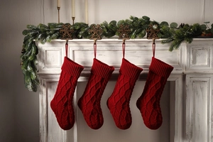 Close-up of four red knitted Christmas stockings with classic cable stitch patterns